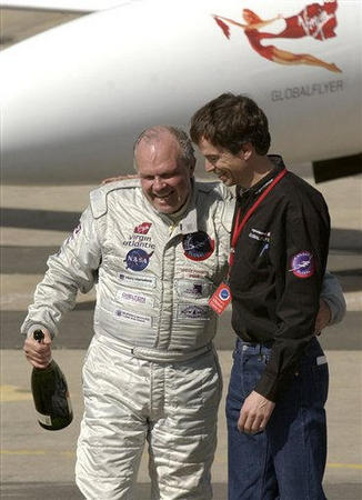 Pilot Steve Fossett, left, and Sir Richard Branson, stand in front of the GlobalFlyer as they give television interviews in a hanger at the Salina Municipal Airport in Salina, Kansas, February 28, 2005.